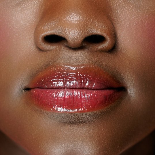 Mulher negra usando Chocoberry Lips da Maybelline NY.