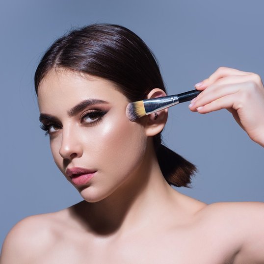 Mulher aprendendo como se maquiar Blush Fit Me da Maybelline NY.