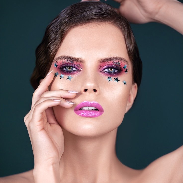 Mulher com maquiagem colorida rosa nos olhos.