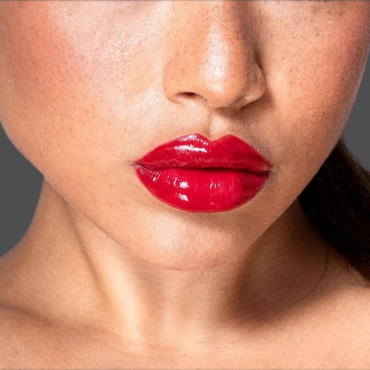 Lábios de uma mulher morena com batom vermelho efeito espelhado