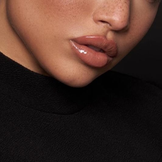 Mulher usando batom líquido e gloss labial em um lip combo nos lábios ideal para seu subtom de pele.