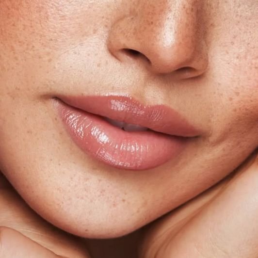 Lábios com batom líquido rosa e gloss labial para dar brilho