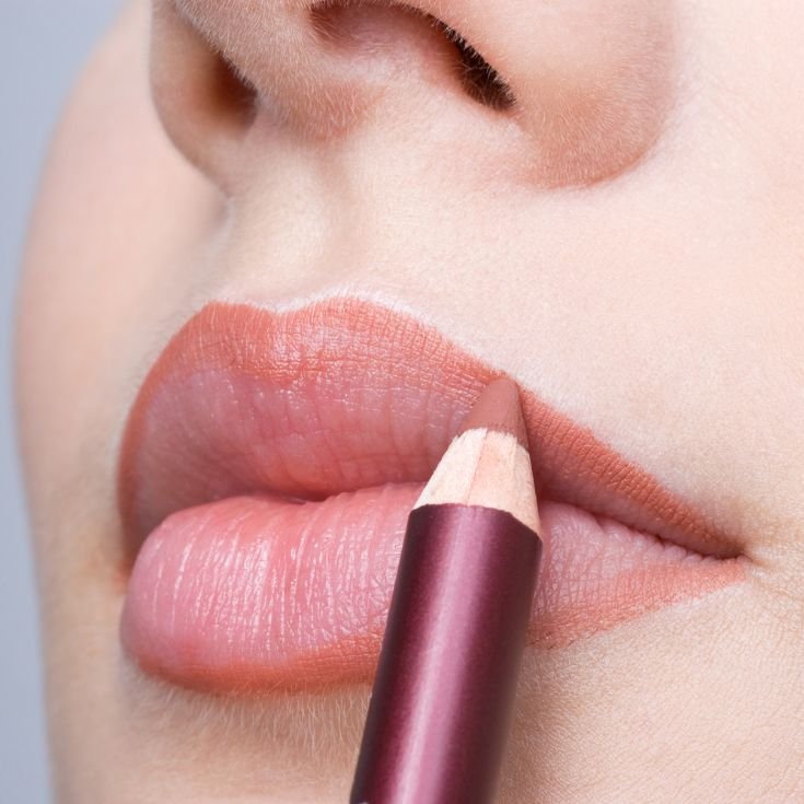 Mulher faz o contorno dos lábios para seu lip combo com um lápis labial