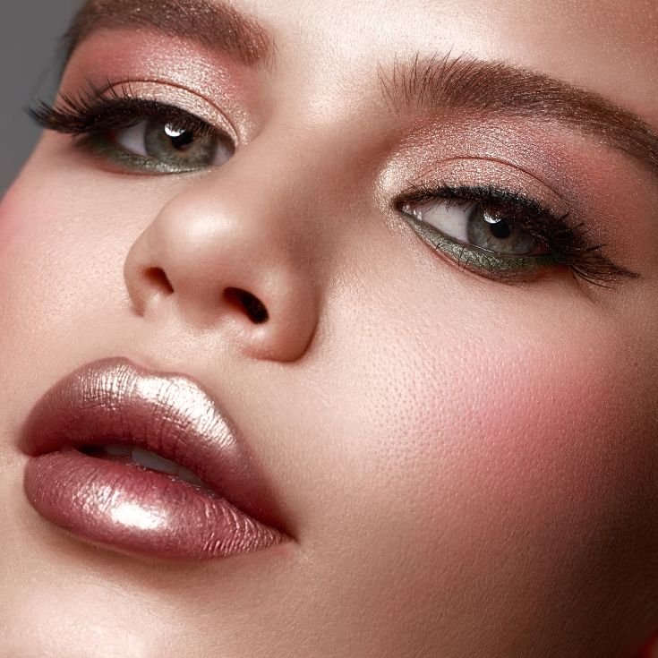 Menina com maquiagem brilhante nos olhos e lábios cintilantes.