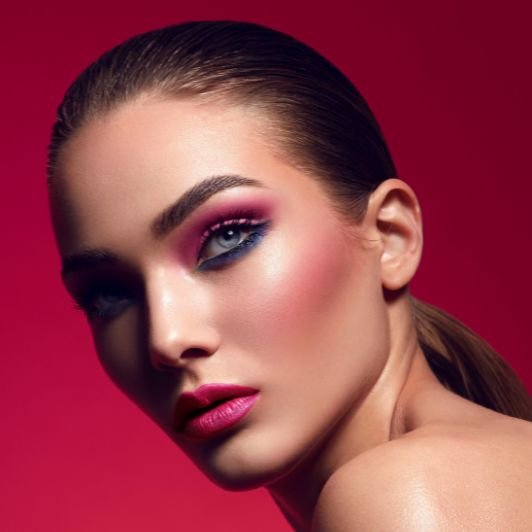 Mulher com maquiagem em tons rosados em fundo rosa.