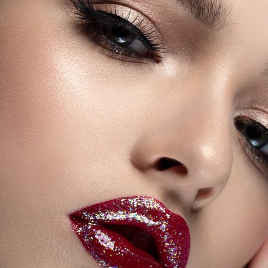 Mulher com gloss com brilho vermelho nos lábios