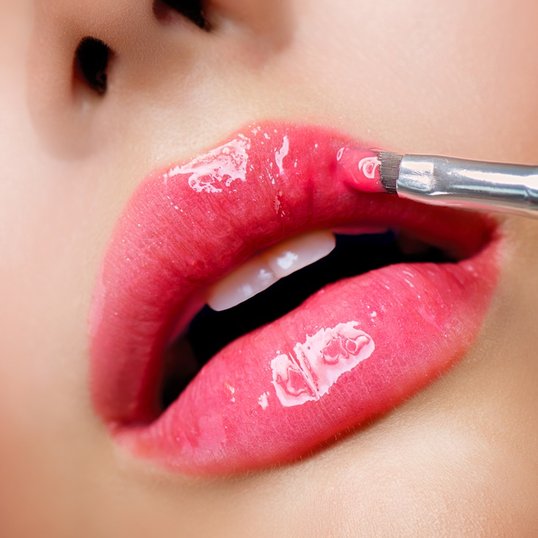 Lábios com gloss com cor rosa.