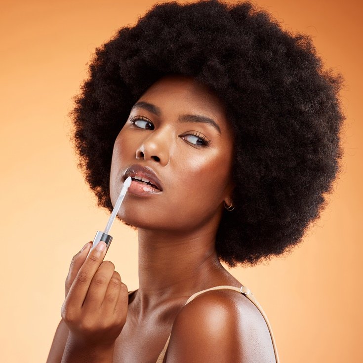 Mulher negra usando Lip Oil nos lábios.