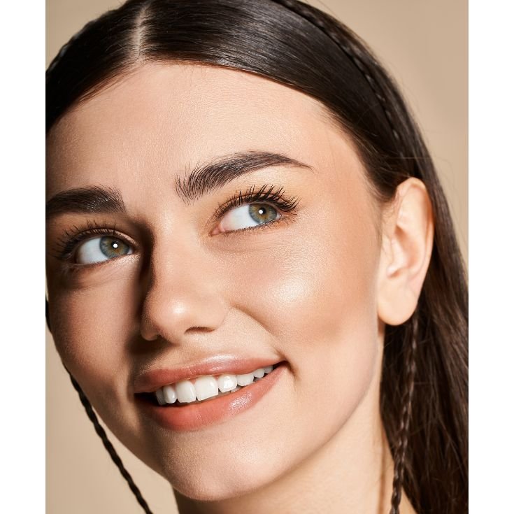 Mulher com pele luminosa e hidratada exibindo acabamento glow de maquiagem.