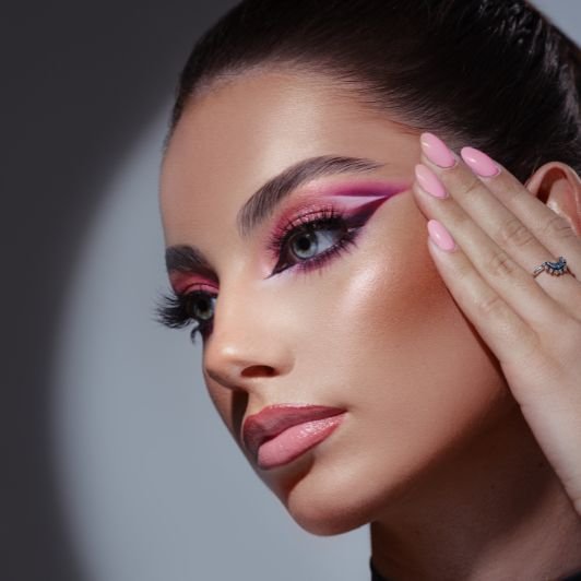 Mulher com delineado rosa feito com sombra e lábios contornados.