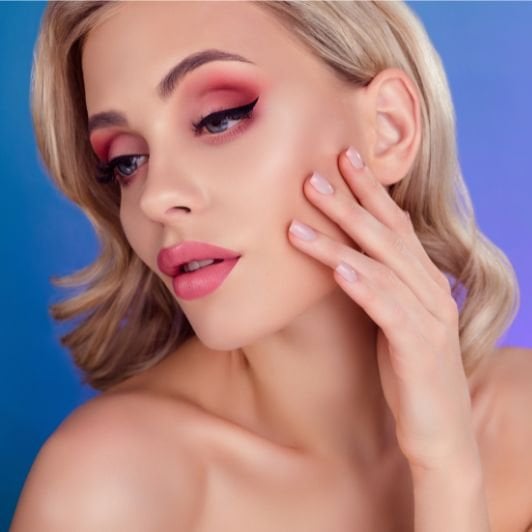 mulher loira com maquiagem de olho esfumado rosa