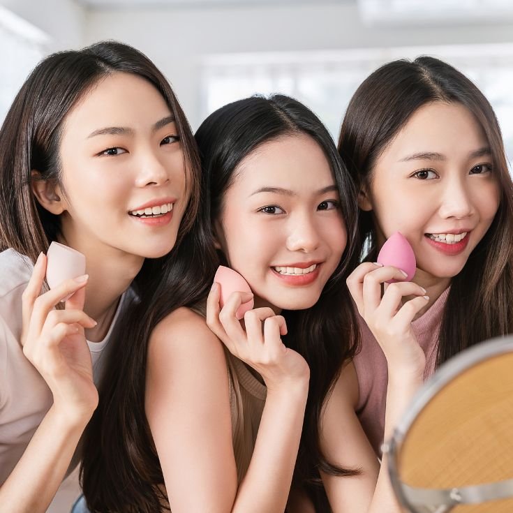 Três amigas felizes seguem juntas o passo a passo para maquiagem