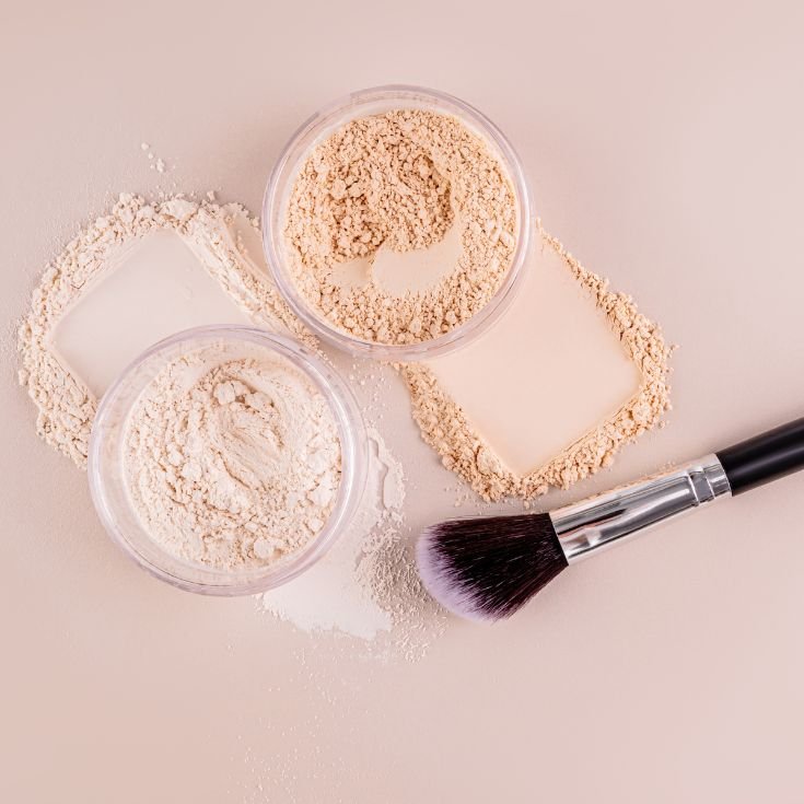 Pó solto com pincel em um fundo bege.
