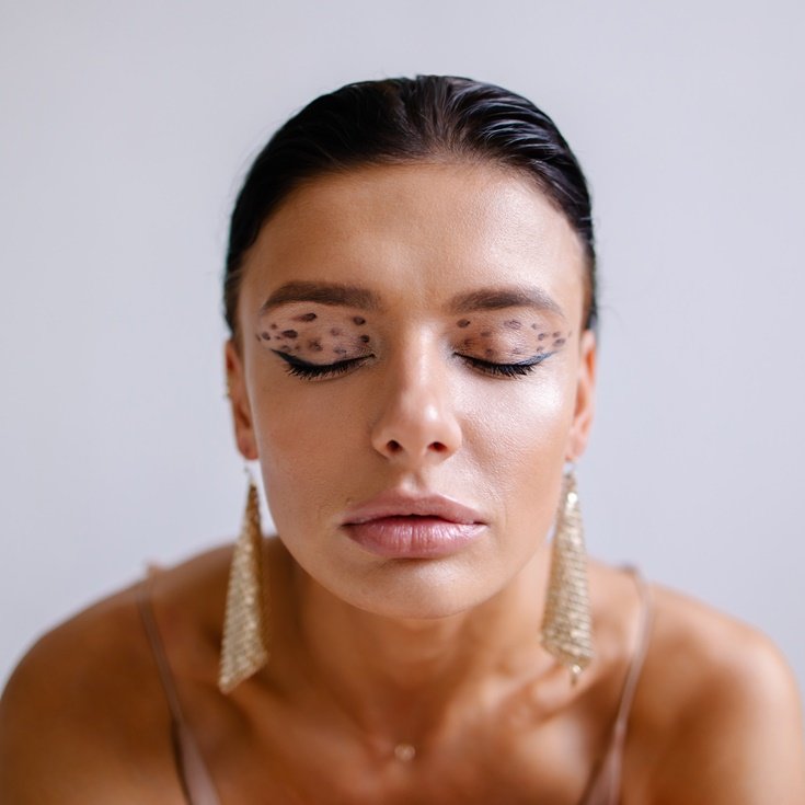 Maquiagem artística para o Carnaval com detalhes dourados e glitter, ideal para um look sofisticado.