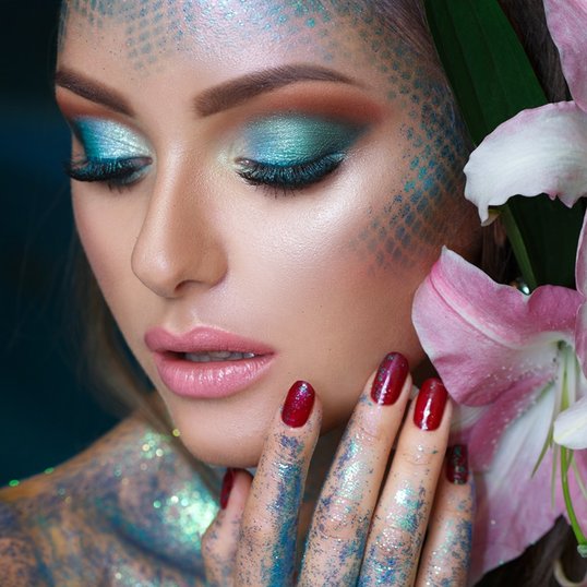 Maquiagem de sereia para o Carnaval, com escamas brilhantes, sombras azuis e detalhes em glitter.