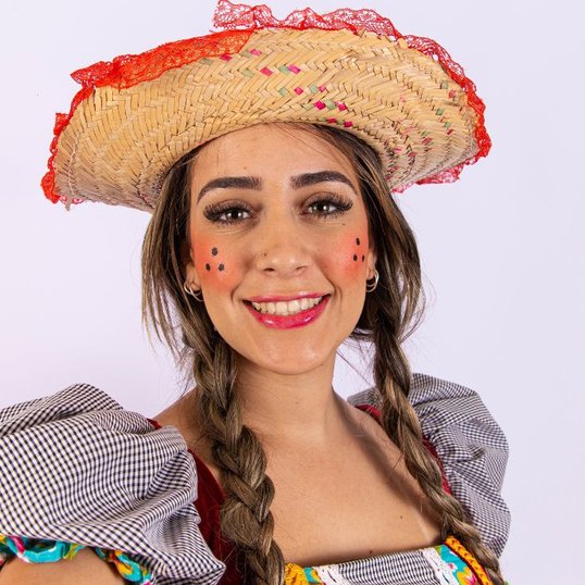 Mulher com maquiagem junina tradicional e bochechas coradas com sardas.