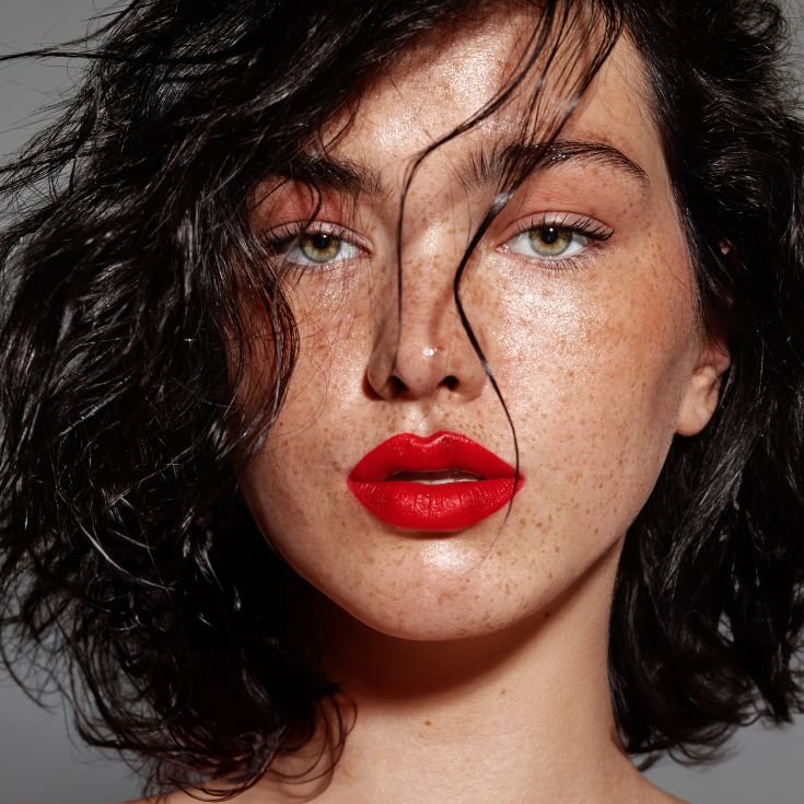 Jovem mulher usa uma maquiagem com batom vermelho