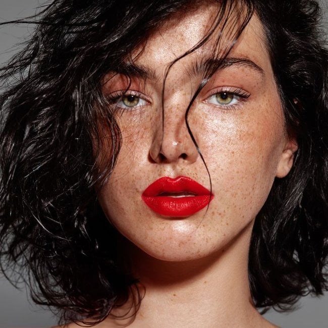 Jovem mulher usa uma maquiagem com batom vermelho