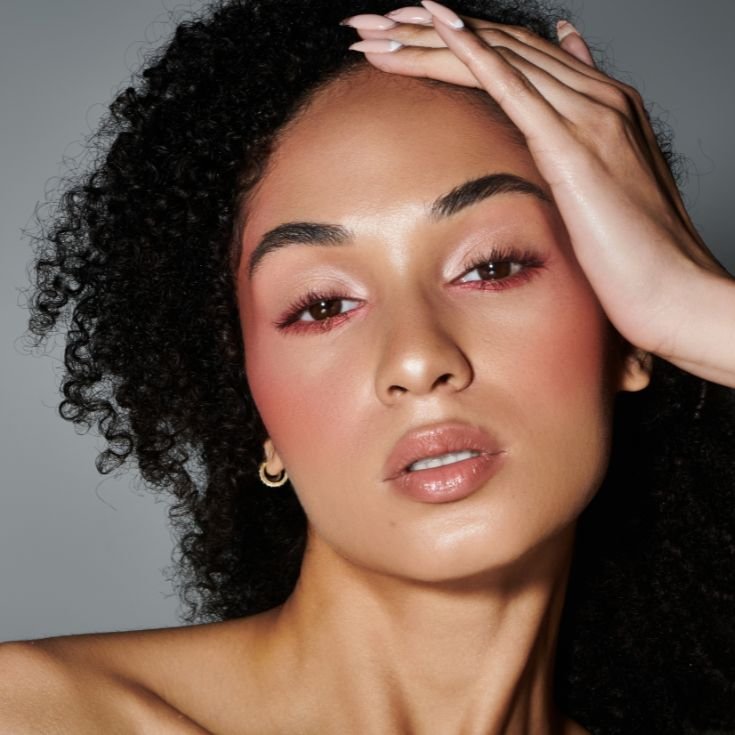 Modelo negra usa bronzer e iluminador em sua maquiagem